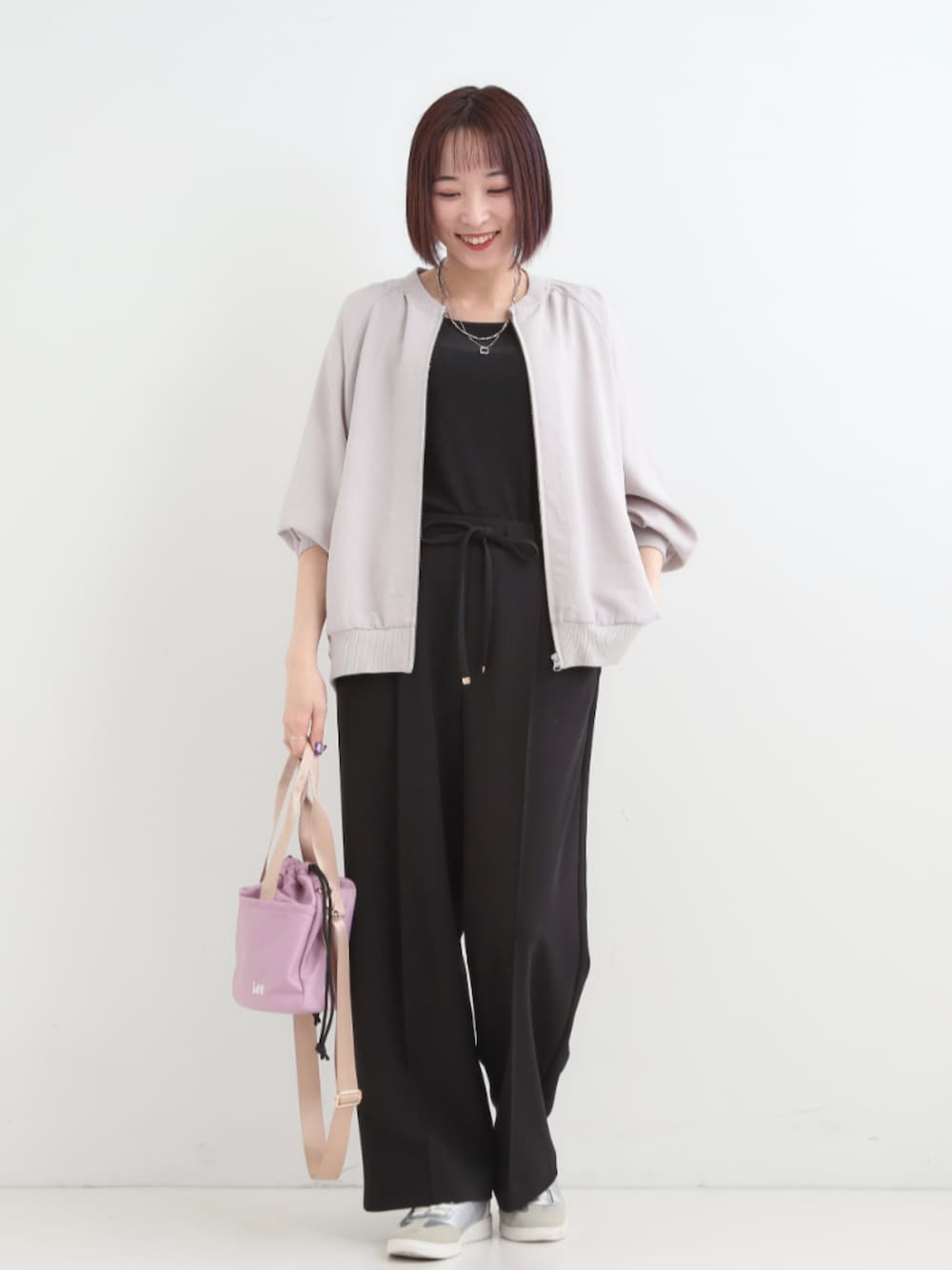 ブラック系のその他パンツ、ピンク系のショルダーバッグ、シルバー系のスニーカーを着用したレディースの春コーディネートの1枚目の写真