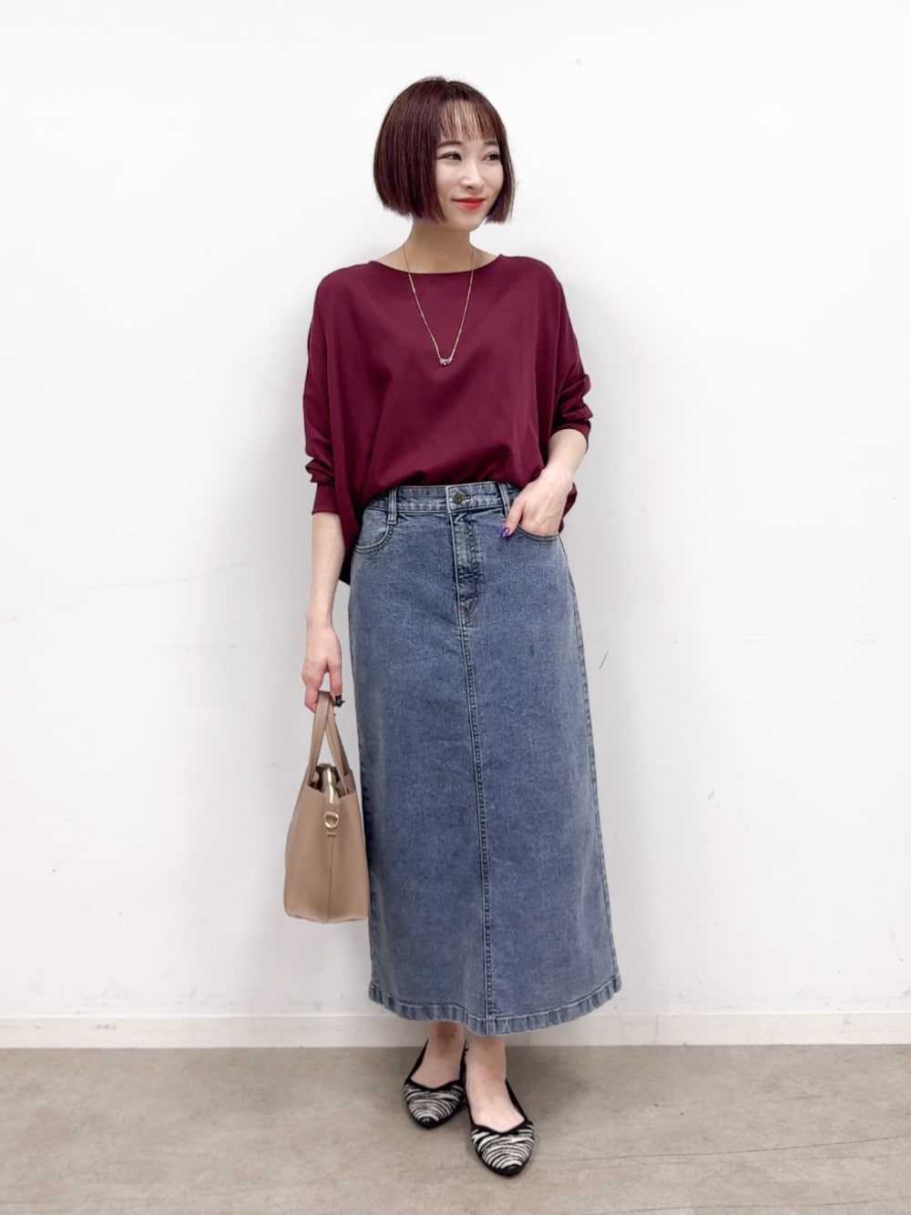 レッド系のシャツ/ブラウス、ブルー系のデニムスカート、ブラック系のパンプスを着用したレディースの秋コーディネートの1枚目の写真