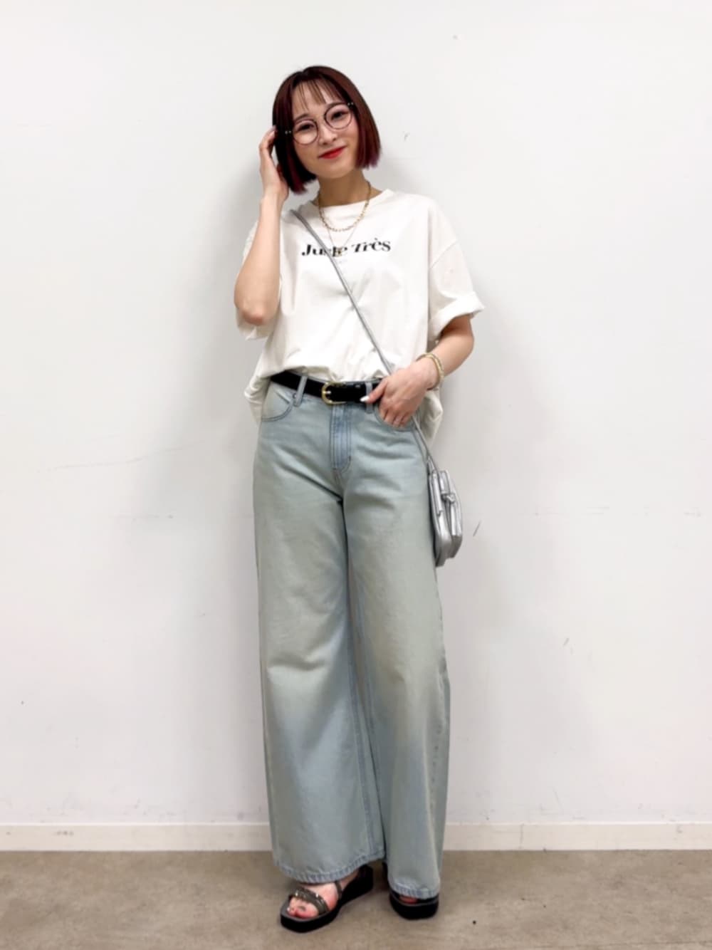 ブルー系のデニムパンツ、シルバー系のショルダーバッグ、ホワイト系のTシャツ/カットソーを着用したレディースの春コーディネートの1枚目の写真