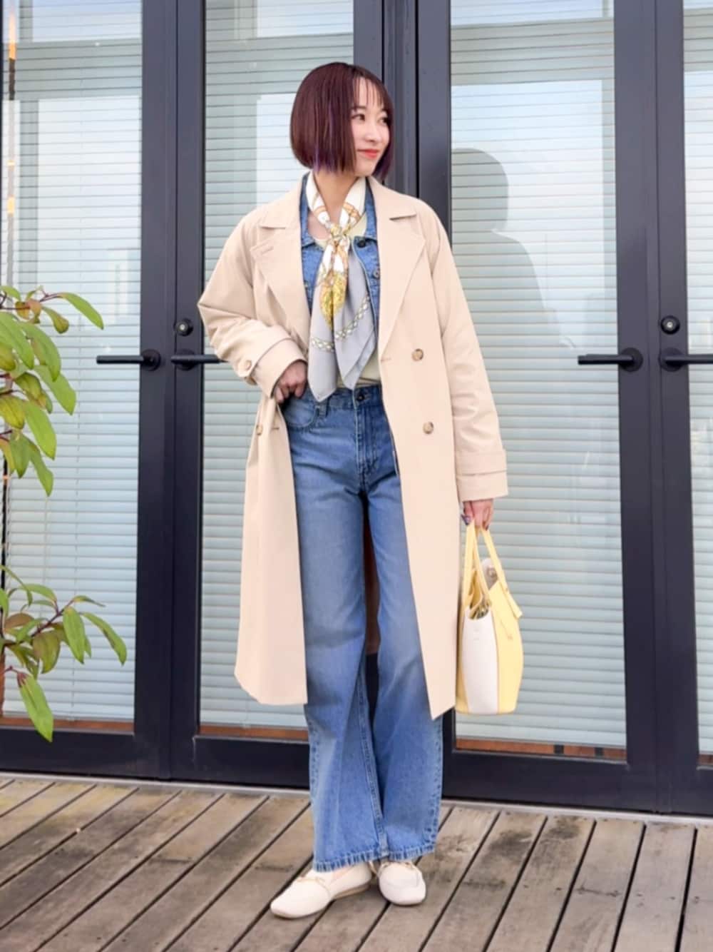 ベージュ系のトレンチコート、ベージュ系のその他シューズ、ブルー系のデニムジャケットを着用したレディースの春コーディネートの1枚目の写真