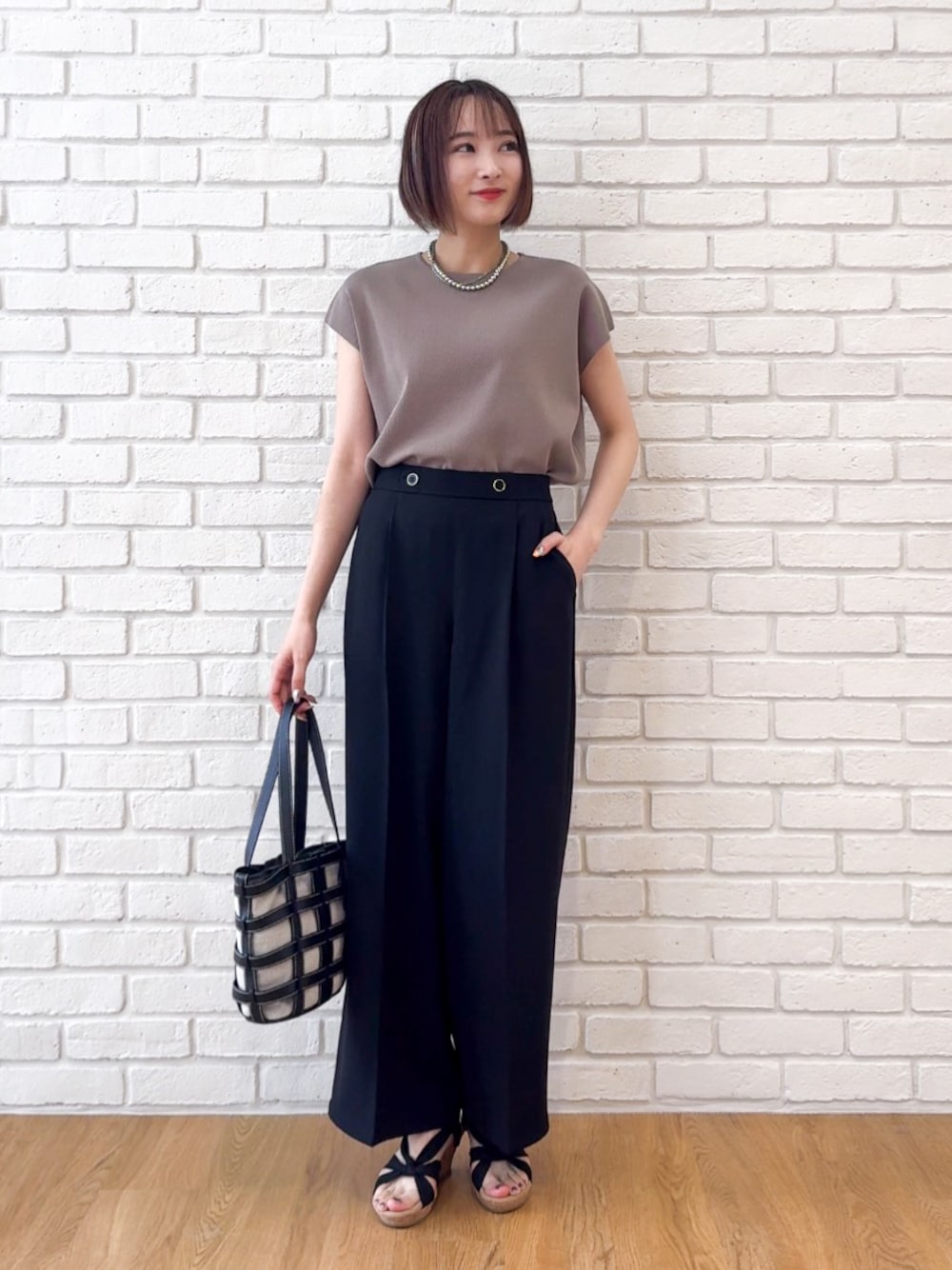 ベージュ系のニット/セーター、ブラック系のその他パンツ、ブラック系のサンダルを着用したレディースの夏コーディネートの1枚目の写真