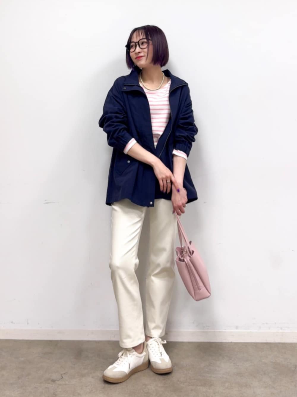 ピンク系のショルダーバッグ、ホワイト系のスニーカー、ピンク系のTシャツ/カットソーを着用したレディースの春コーディネートの1枚目の写真