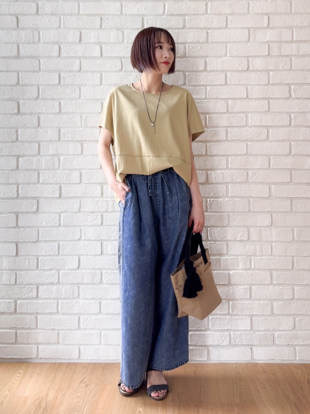 イエロー系のTシャツ/カットソー、ブルー系のデニムパンツ、ブラック系のサンダルを着用したレディースの夏コーディネートの1枚目の写真