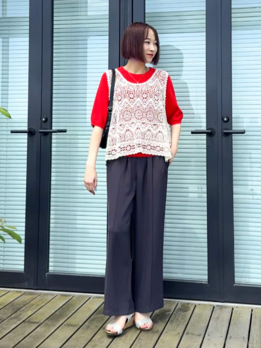 ブラック系のショルダーバッグ、グレー系のその他パンツ、レッド系のニット/セーターを着用したレディースの春コーディネートの1枚目の写真