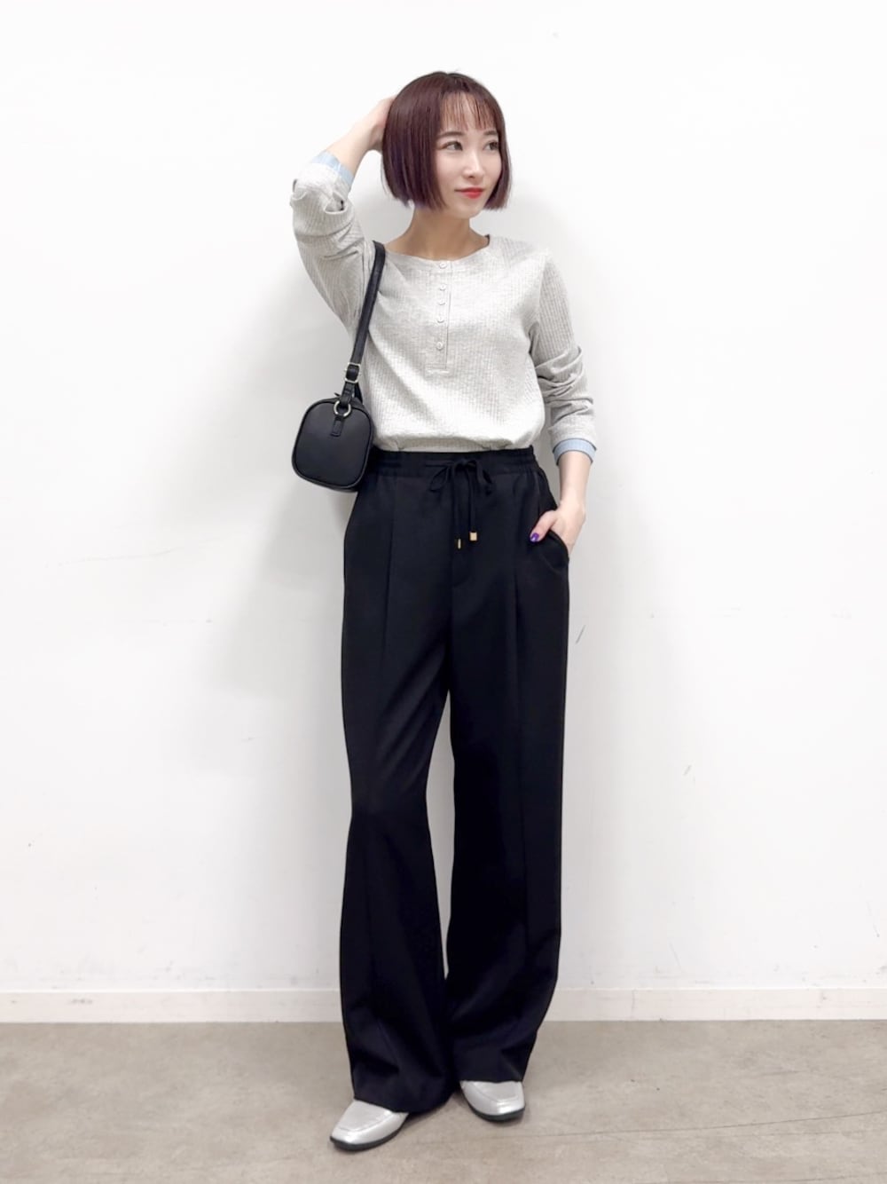 グレー系のTシャツ/カットソー、ブラック系のその他パンツ、シルバー系のパンプスを着用したレディースの秋コーディネートの1枚目の写真