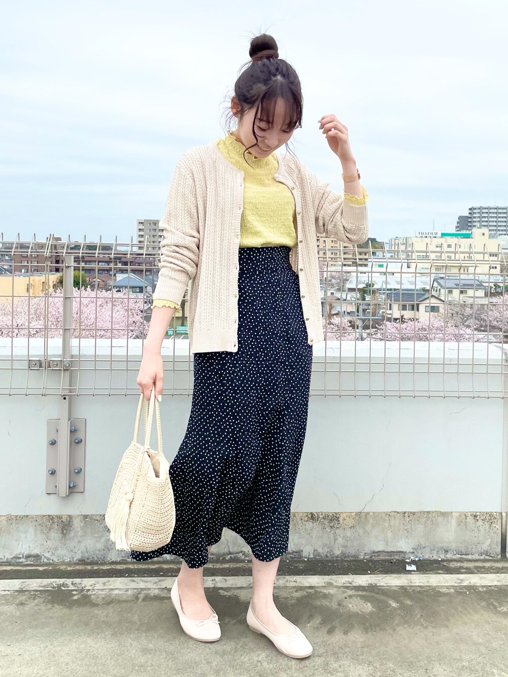 ホワイト系のカーディガン/ボレロ、イエロー系のTシャツ/カットソー、ブラック系のスカートを着用したレディースの春コーディネートの1枚目の写真