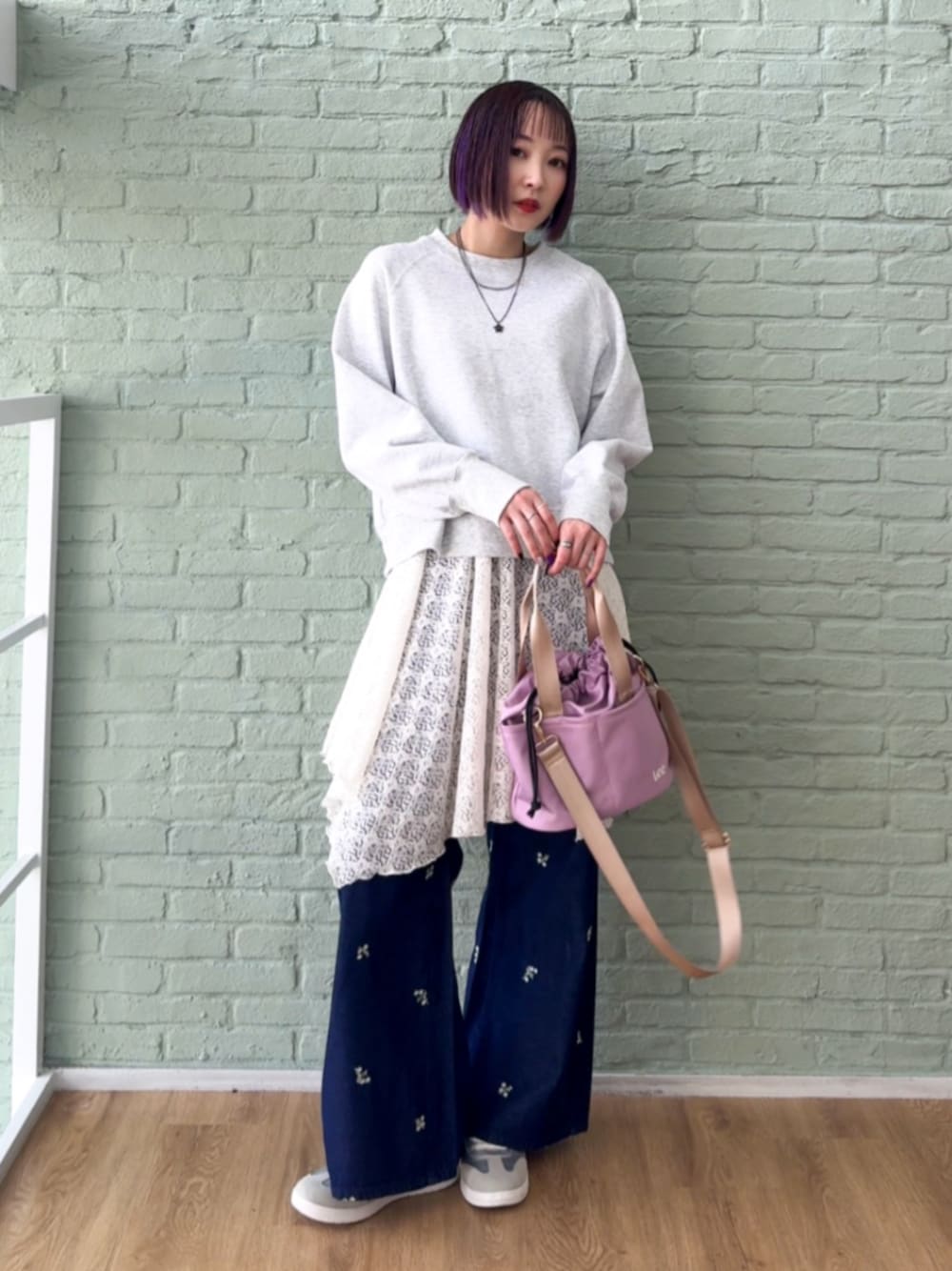 グレー系のスウェット、ピンク系のショルダーバッグ、シルバー系のスニーカーを着用したレディースの春コーディネートの1枚目の写真