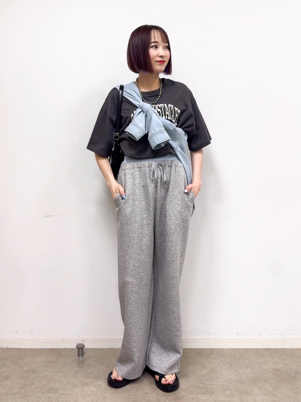 ブルー系のシャツ/ブラウス、グレー系のその他パンツ、ブラック系のショルダーバッグを着用したレディースの春コーディネートの1枚目の写真