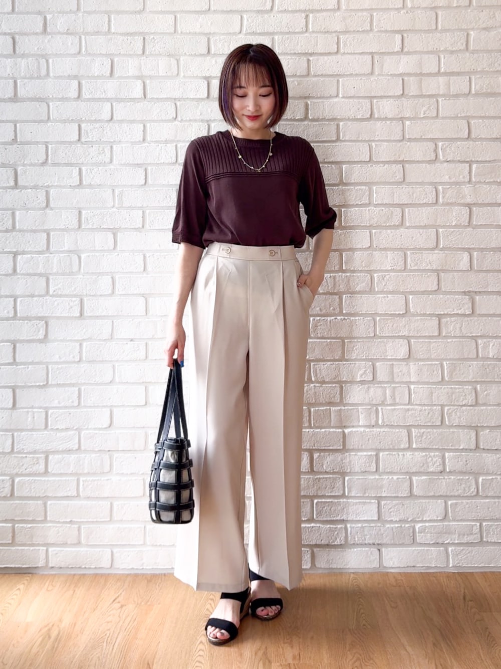 ベージュ系のその他パンツ、ブラック系のサンダル、ブラック系のトートバッグを着用したレディースの夏コーディネートの1枚目の写真