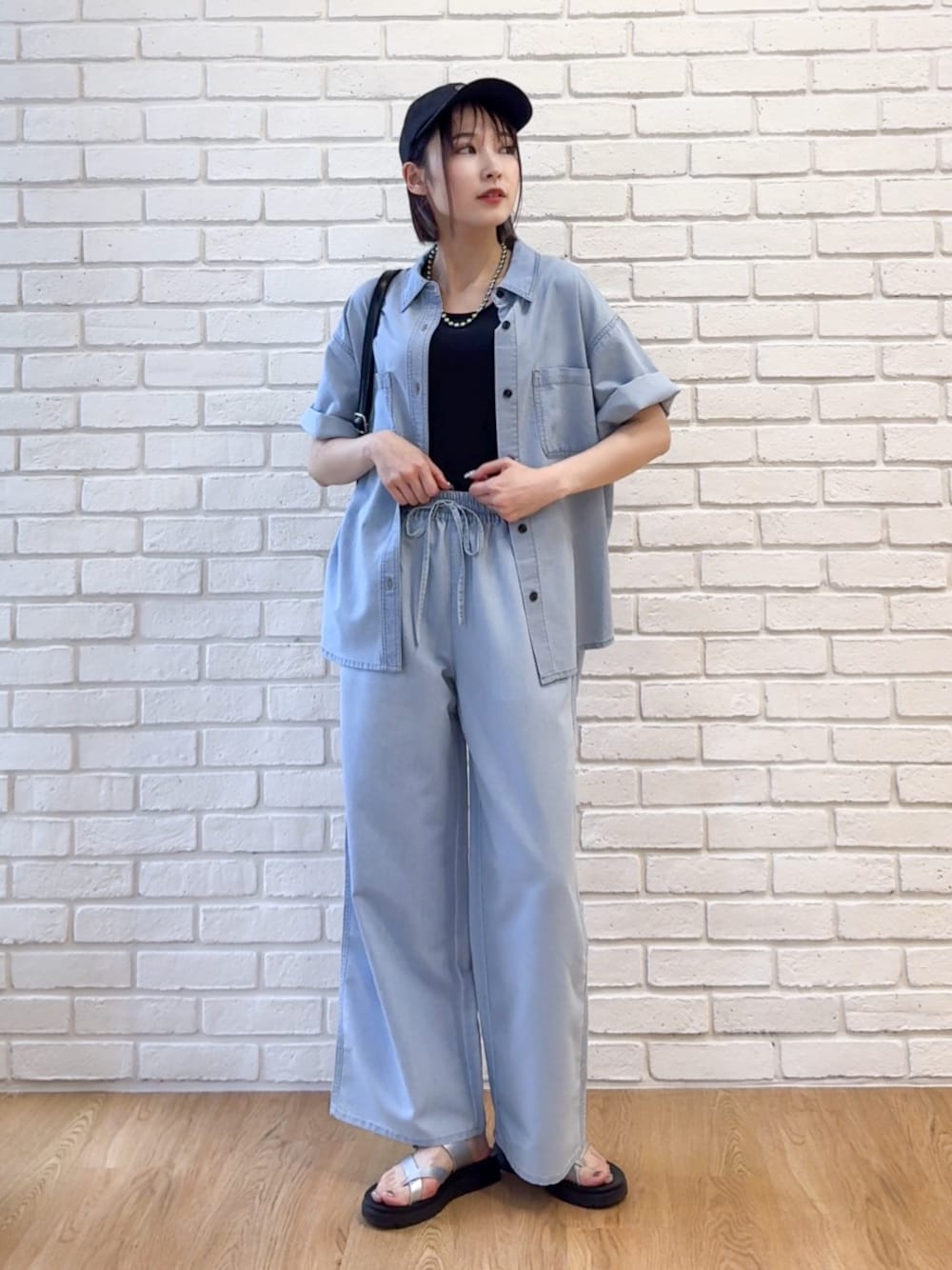 ブルー系のシャツ/ブラウス、ブラック系のタンクトップ、ブルー系のデニムパンツを着用したレディースの夏コーディネートの1枚目の写真