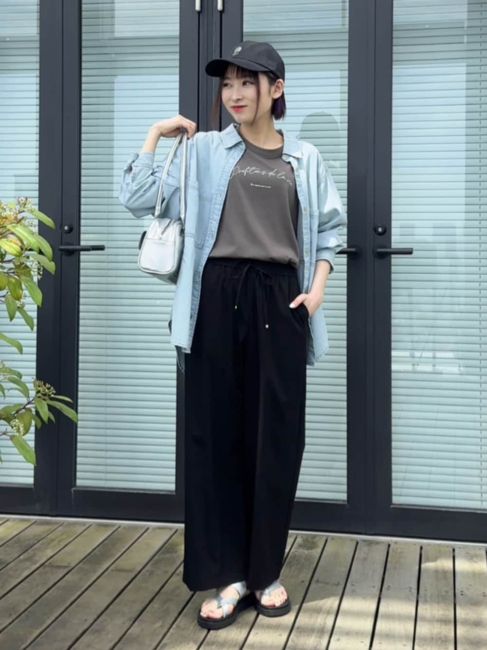 シルバー系のボストンバッグ、ブルー系のシャツ/ブラウス、グレー系のTシャツ/カットソーを着用したレディースの春コーディネートの1枚目の写真