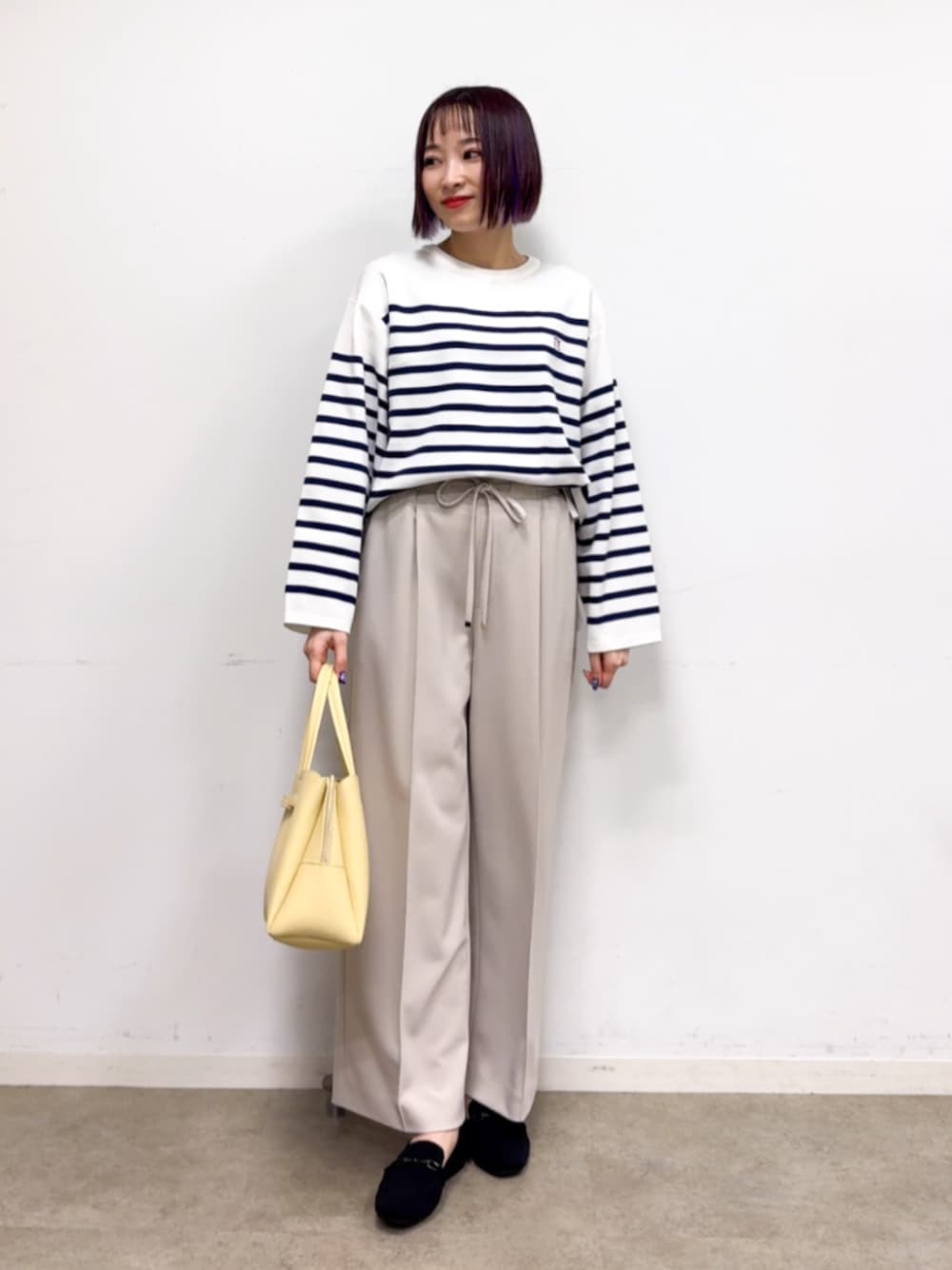 ブラック系のその他シューズ、イエロー系のトートバッグ、ベージュ系のその他パンツを着用したレディースの春コーディネートの1枚目の写真