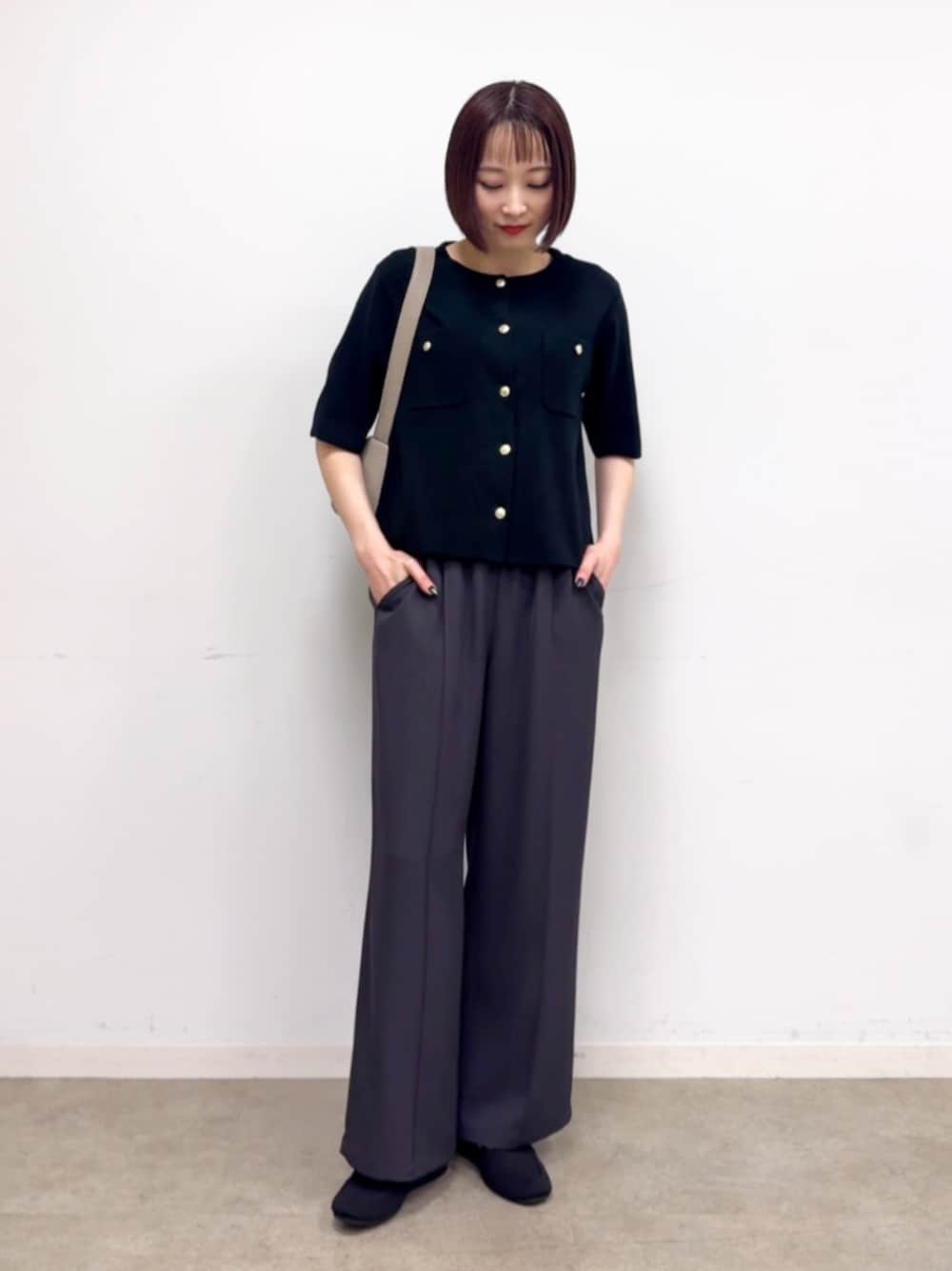 ベージュ系のショルダーバッグ、ブラック系のその他シューズ、グレー系のその他パンツを着用したレディースの春コーディネートの1枚目の写真