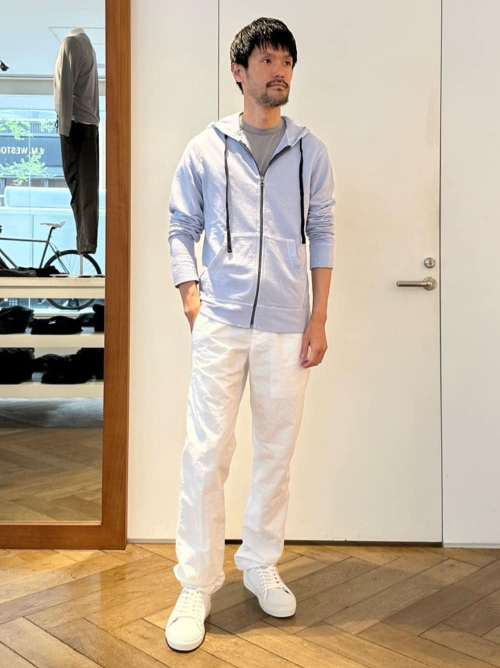 ホワイト系のスニーカー、ブルー系のパーカー、ホワイト系のその他パンツを着用したメンズの春コーディネートの1枚目の写真