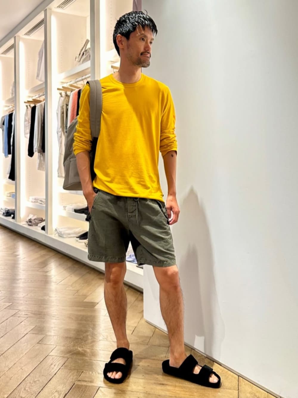 グレー系のバックパック/リュック、イエロー系のTシャツ/カットソー、グリーン系のその他パンツを着用したメンズの夏コーディネートの1枚目の写真