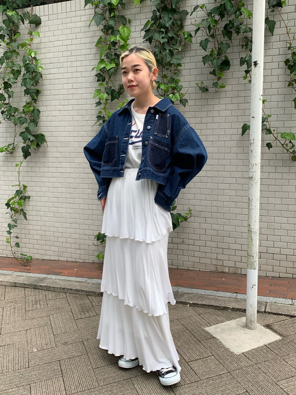 ブルー系のデニムジャケット、ホワイト系のスカートを着用したレディースの春コーディネートの1枚目の写真