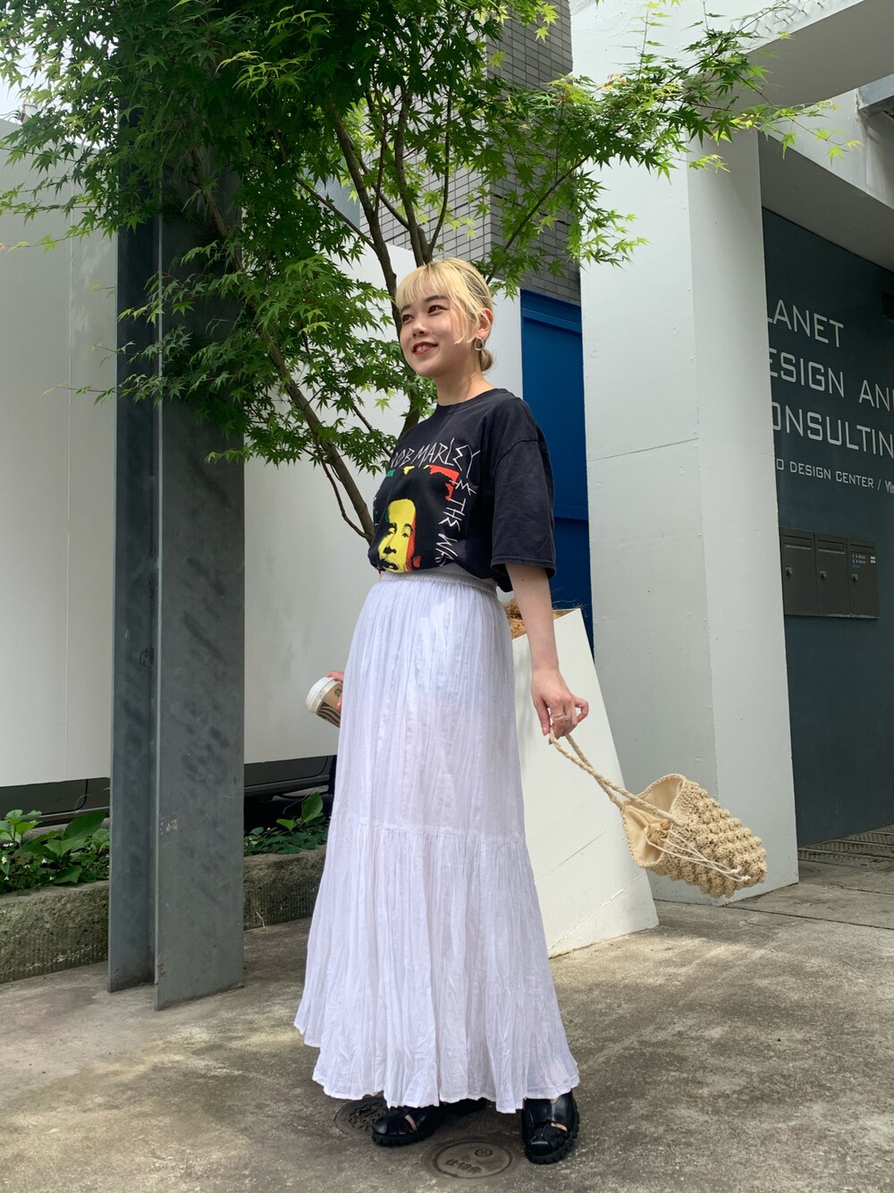 ホワイト系のスカート、イエロー系のTシャツ/カットソーを着用したレディースの春コーディネートの1枚目の写真