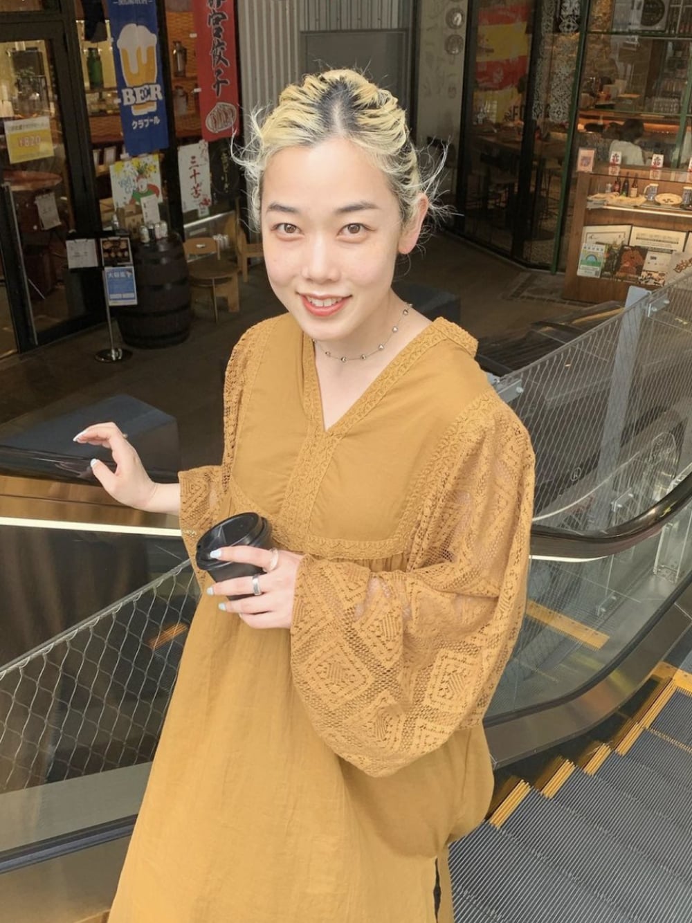 イエロー系のワンピースを着用したレディースの春コーディネートの1枚目の写真