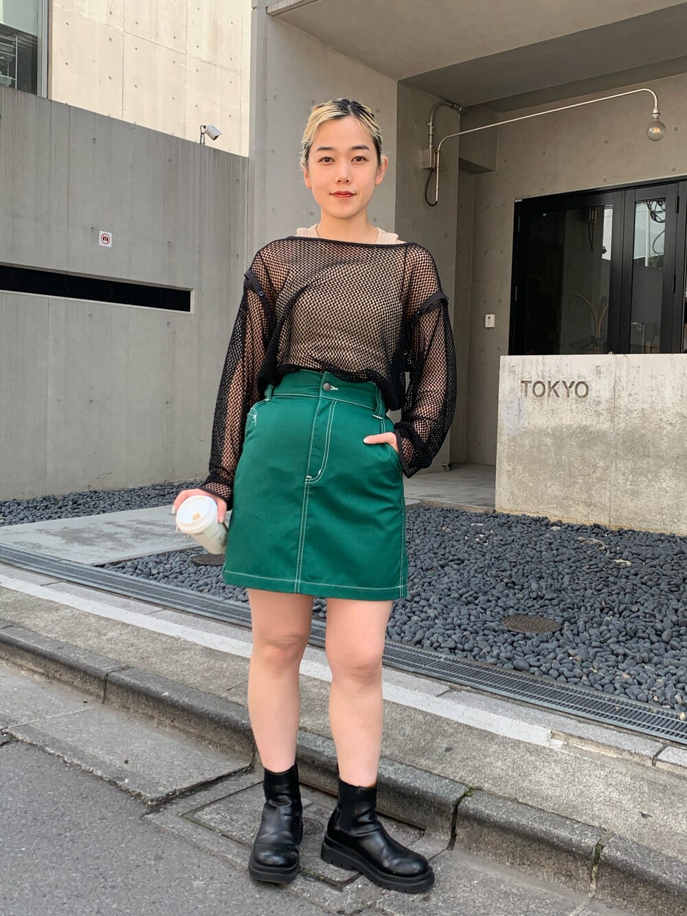 ブラック系のTシャツ/カットソー、グリーン系のスカートを着用したレディースの春コーディネートの1枚目の写真