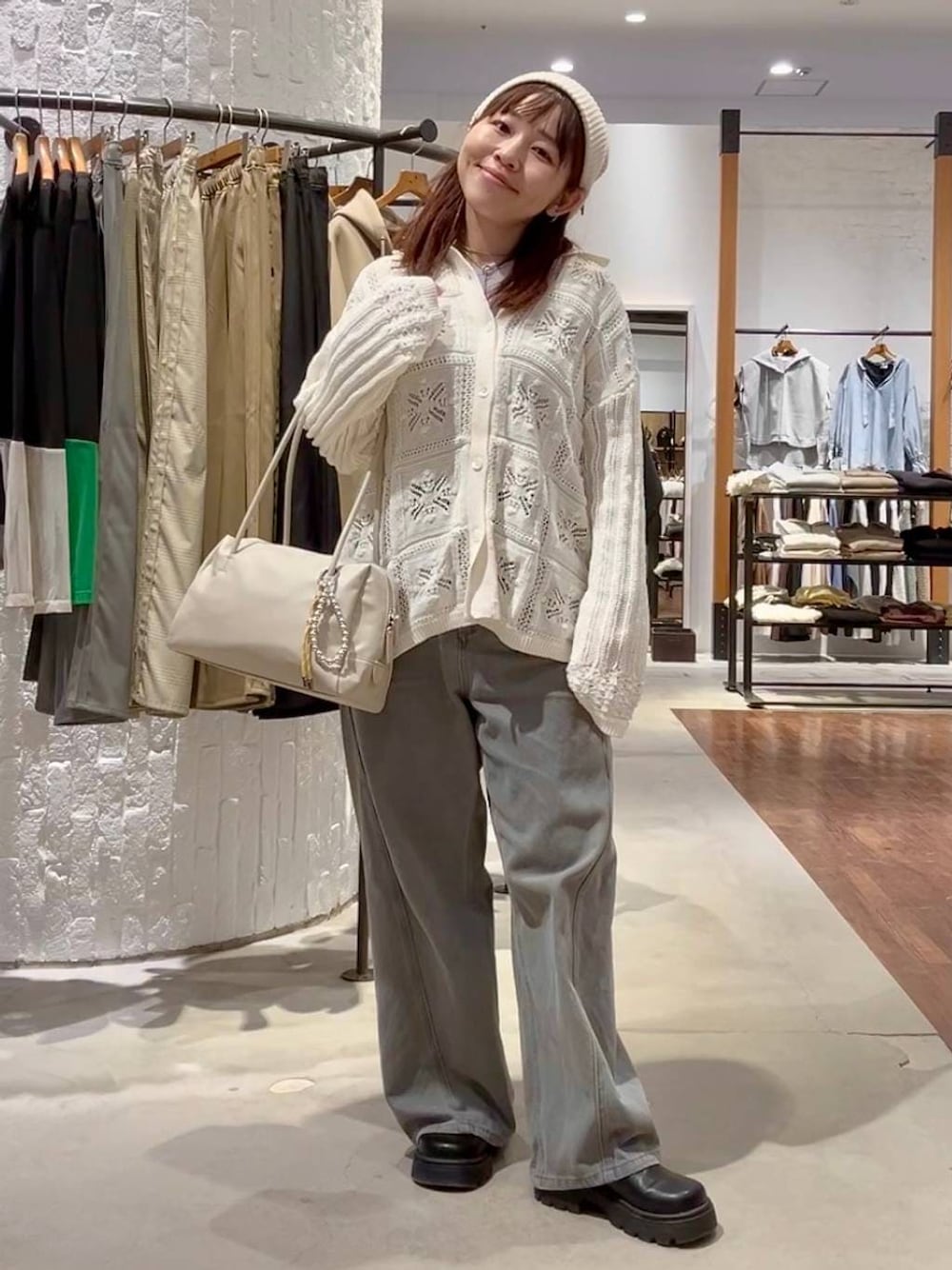 パープル系のTシャツ/カットソー、グレー系のデニムパンツ、ホワイト系のボストンバッグを着用したレディースの冬コーディネートの1枚目の写真