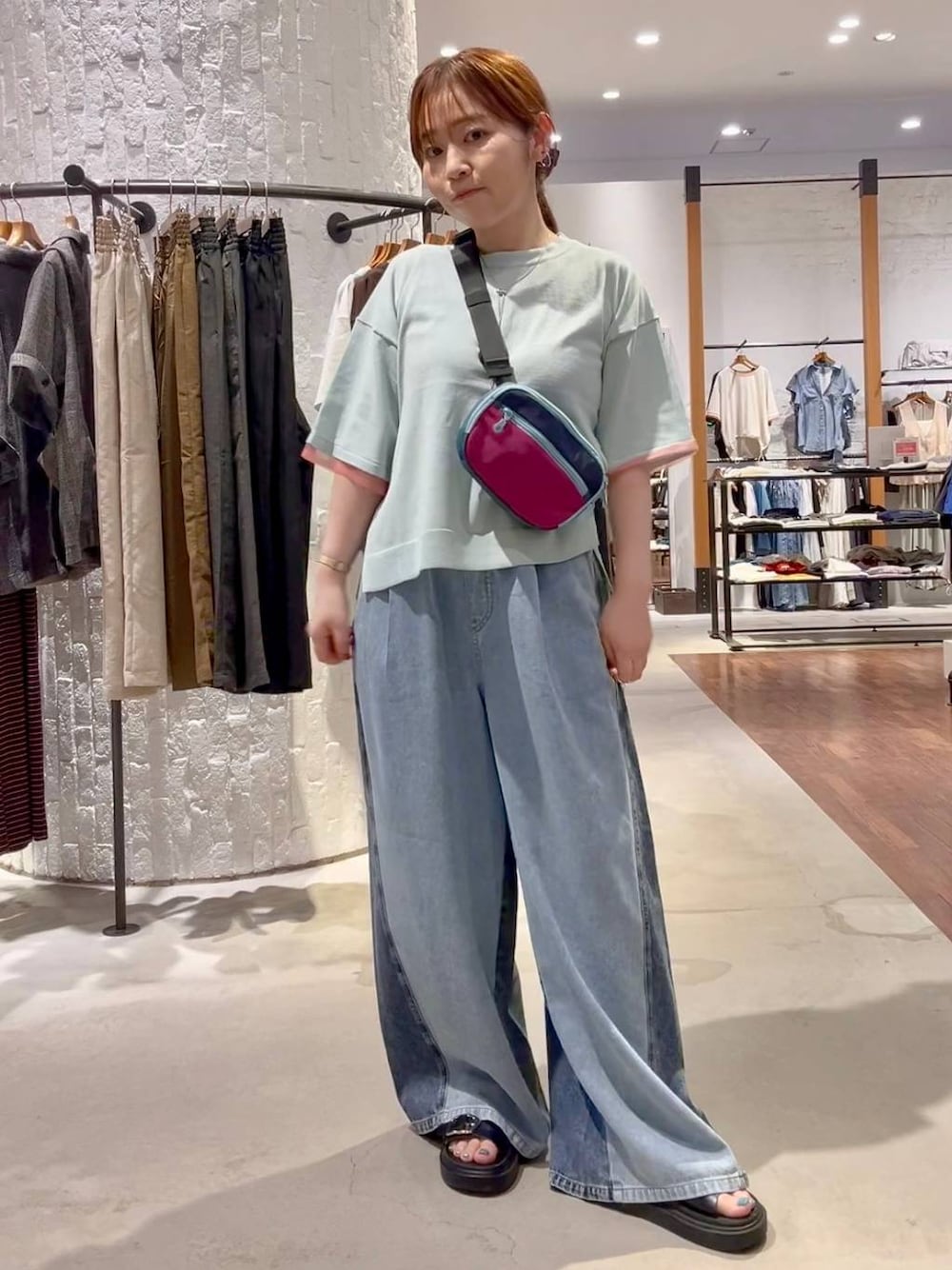 ブルー系のニット/セーター、ブルー系のデニムパンツ、ブラック系のサンダルを着用したレディースの夏コーディネートの1枚目の写真
