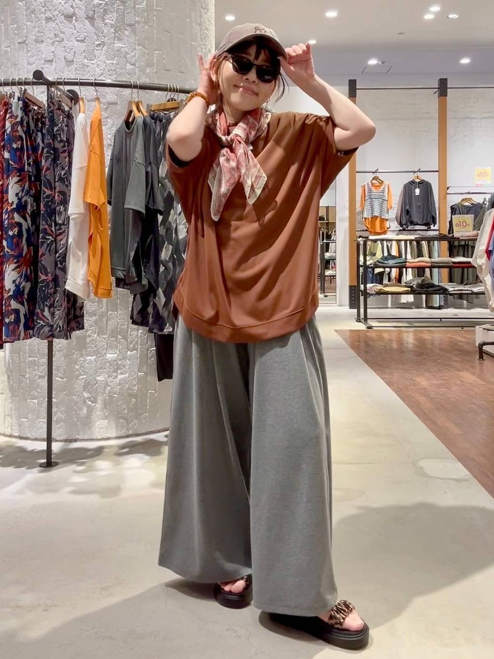 グレー系のその他パンツ、その他のサンダル、ブラウン系のTシャツ/カットソーを着用したレディースの春コーディネートの1枚目の写真