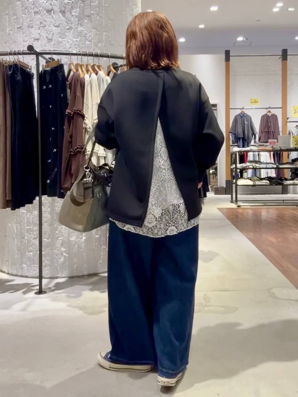 ブルー系のスニーカー、グリーン系のショルダーバッグ、ブルー系のデニムパンツを着用したレディースの秋コーディネートの1枚目の写真