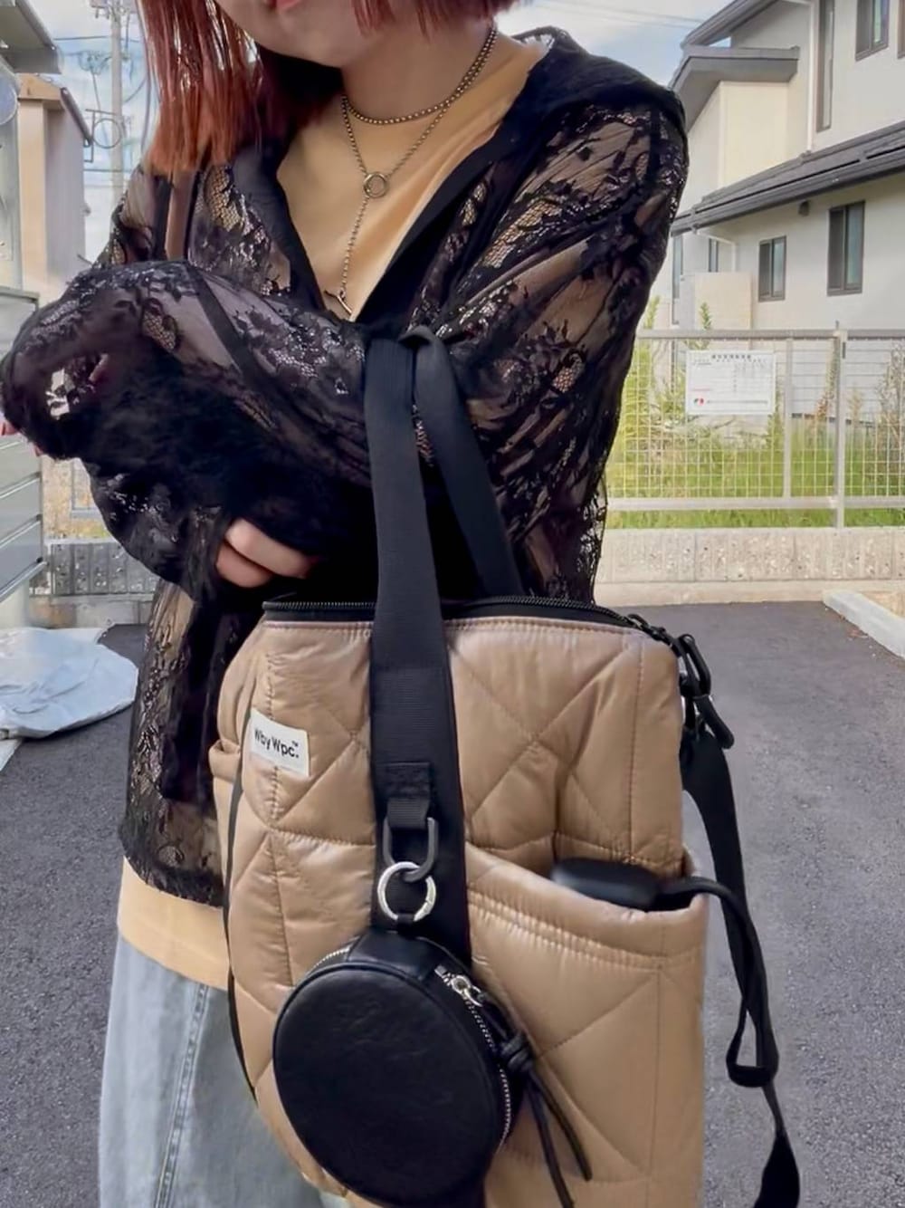 ブラック系のシャツ/ブラウス、ブルー系のスニーカー、ブルー系のデニムパンツを着用したレディースの秋コーディネートの1枚目の写真