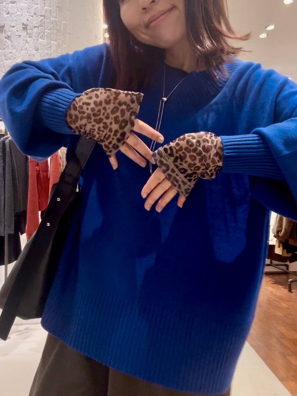 ブルー系のニット/セーター、その他のTシャツ/カットソー、ブラック系のショルダーバッグを着用したレディースの秋コーディネートの1枚目の写真