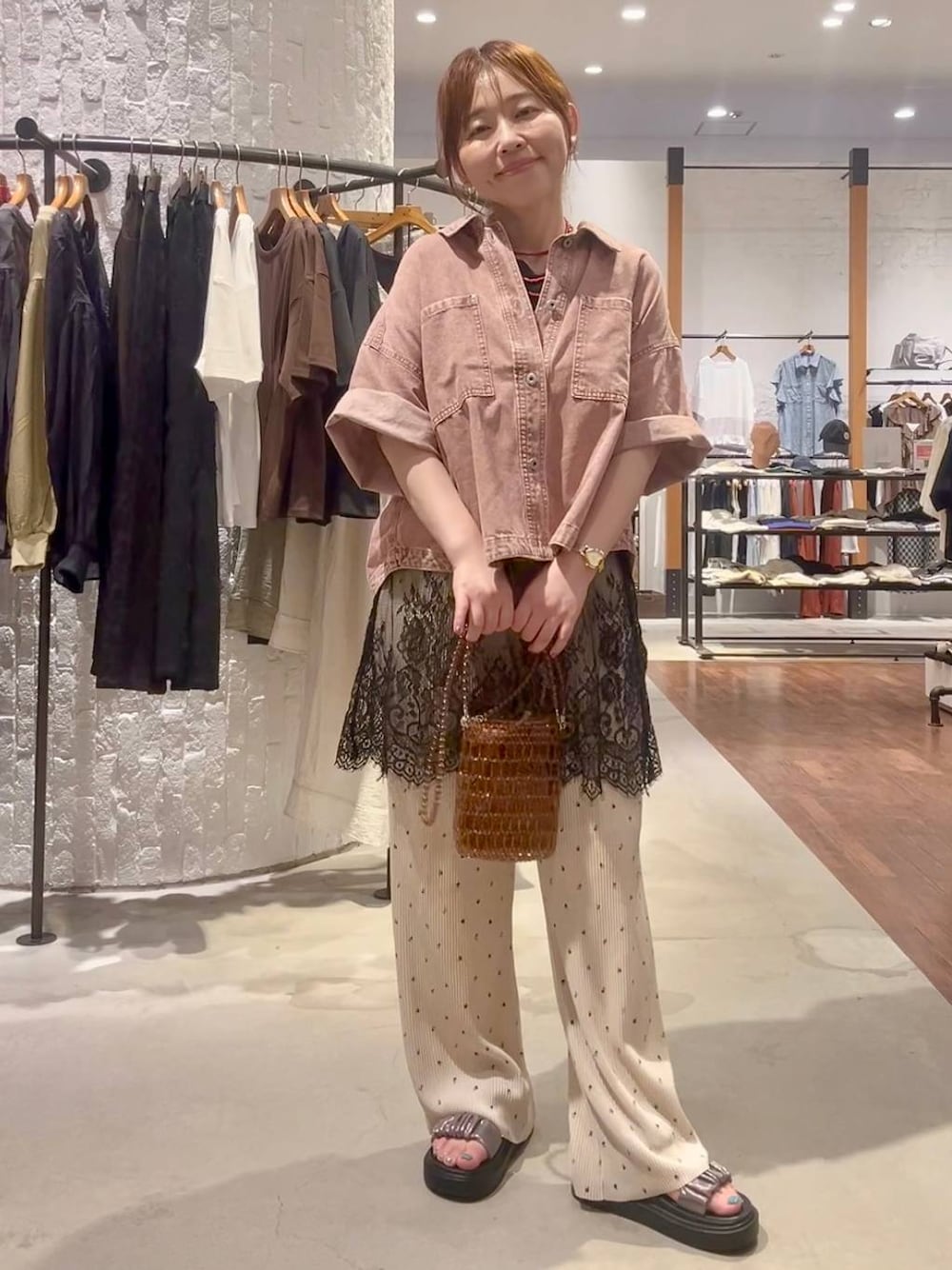 ベージュ系のその他パンツ、その他のサンダル、ブラウン系のショルダーバッグを着用したレディースの夏コーディネートの1枚目の写真
