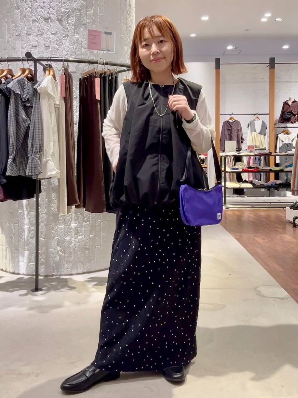 ブラック系のベスト、ブラック系のローファー、ホワイト系のTシャツ/カットソーを着用したレディースの秋コーディネートの1枚目の写真