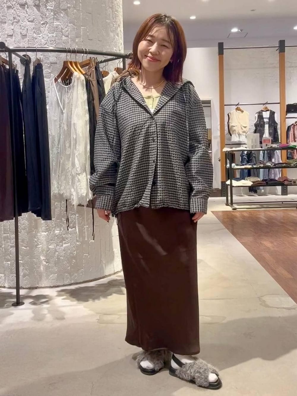 グレー系のサンダル、ブラウン系のスカート、ブラック系のシャツ/ブラウスを着用したレディースの夏コーディネートの1枚目の写真