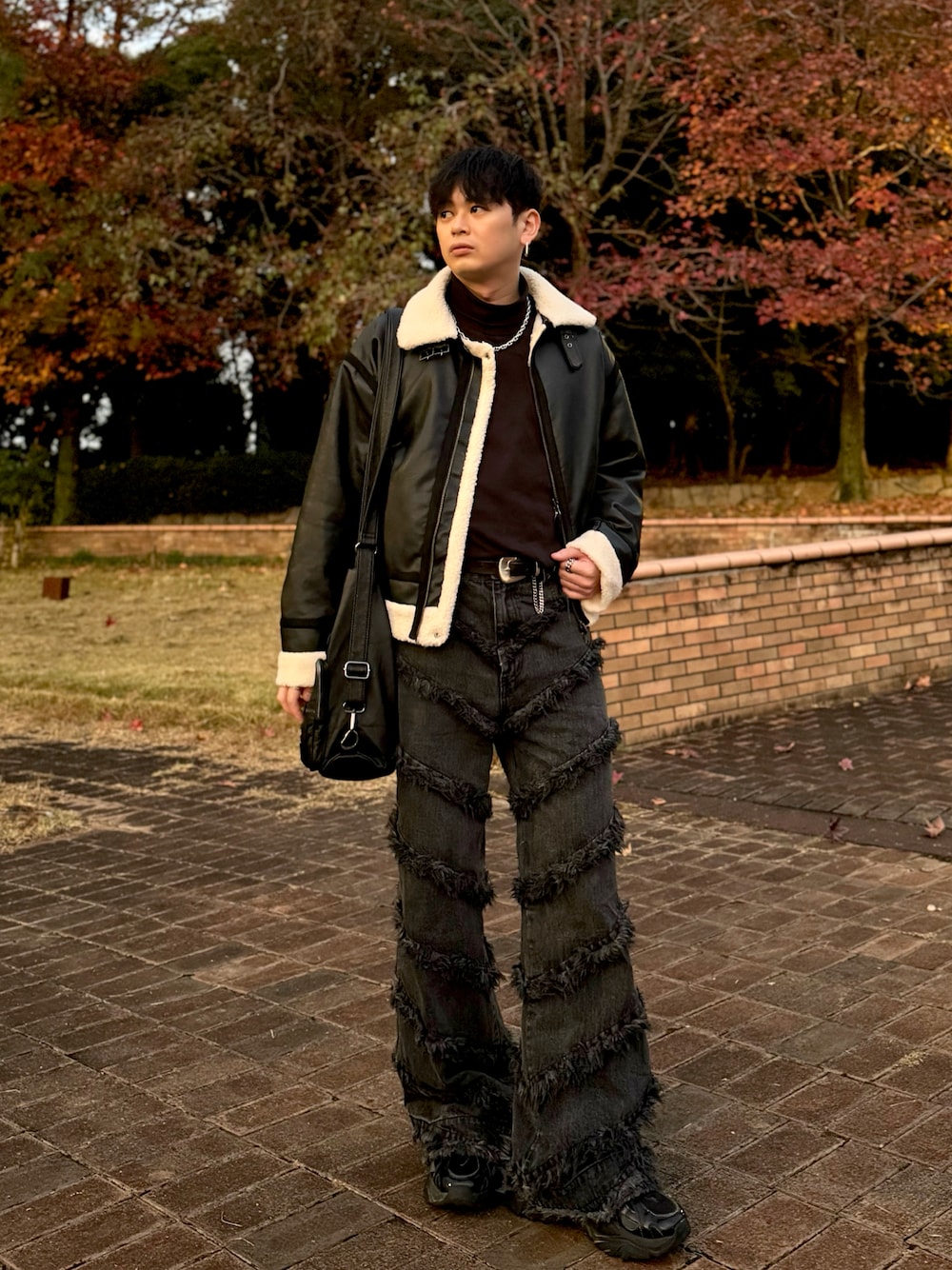 ブラック系のブルゾン、ブラック系のデニムパンツ、ブラック系のショルダーバッグを着用したメンズの秋コーディネートの1枚目の写真