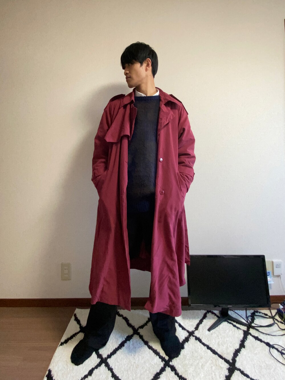 ブルー系のニット/セーター、ブラック系のセットアップ、ピンク系のトレンチコートを着用したメンズの冬コーディネートの1枚目の写真