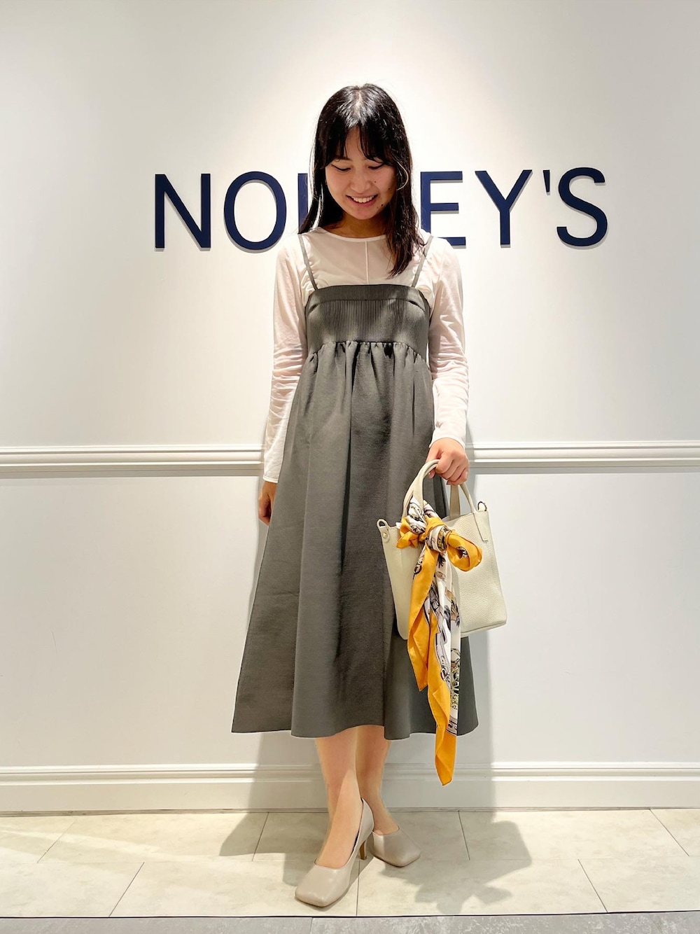 ホワイト系のTシャツ/カットソー、グレー系のスカート、ホワイト系のトートバッグを着用したレディースの秋コーディネートの1枚目の写真