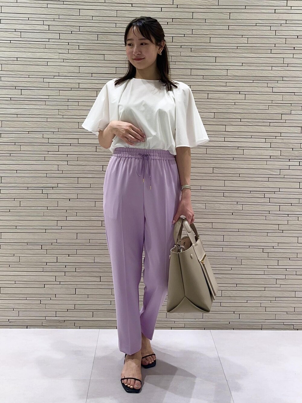 ベージュ系のハンドバッグ、ブラック系のサンダル、パープル系のその他パンツを着用したレディースの夏コーディネートの1枚目の写真