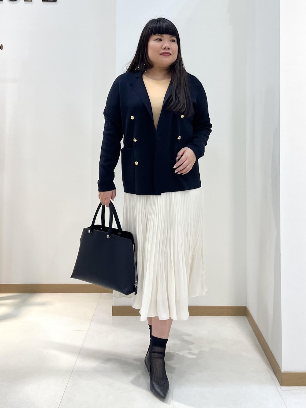 ホワイト系のスカート、ブルー系のテーラードジャケット、オレンジ系のTシャツ/カットソーを着用したレディースの春コーディネートの1枚目の写真