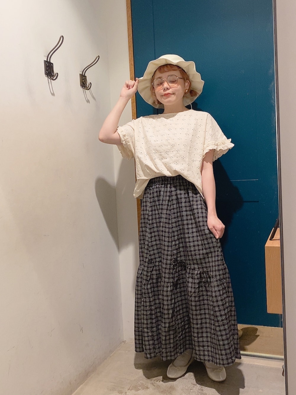 ホワイト系のTシャツ/カットソー、ブラック系のスカート、ホワイト系のパンプスを着用したレディースの夏コーディネートの1枚目の写真