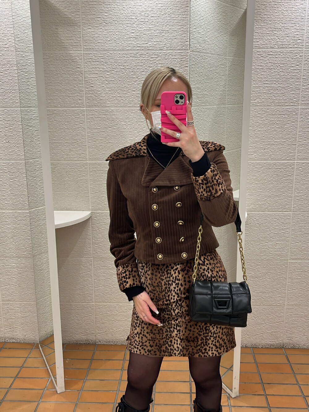 ブラウン系のフォーマルスーツ/小物、ブラック系のバッグを着用したレディースの冬コーディネートの1枚目の写真