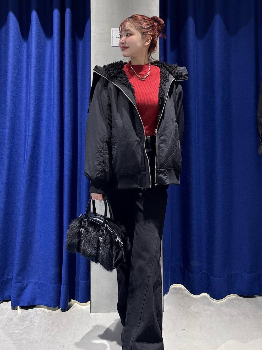 ブラック系のデニムパンツ、ブラック系のブルゾン、レッド系のニット/セーターを着用したレディースの秋コーディネートの1枚目の写真