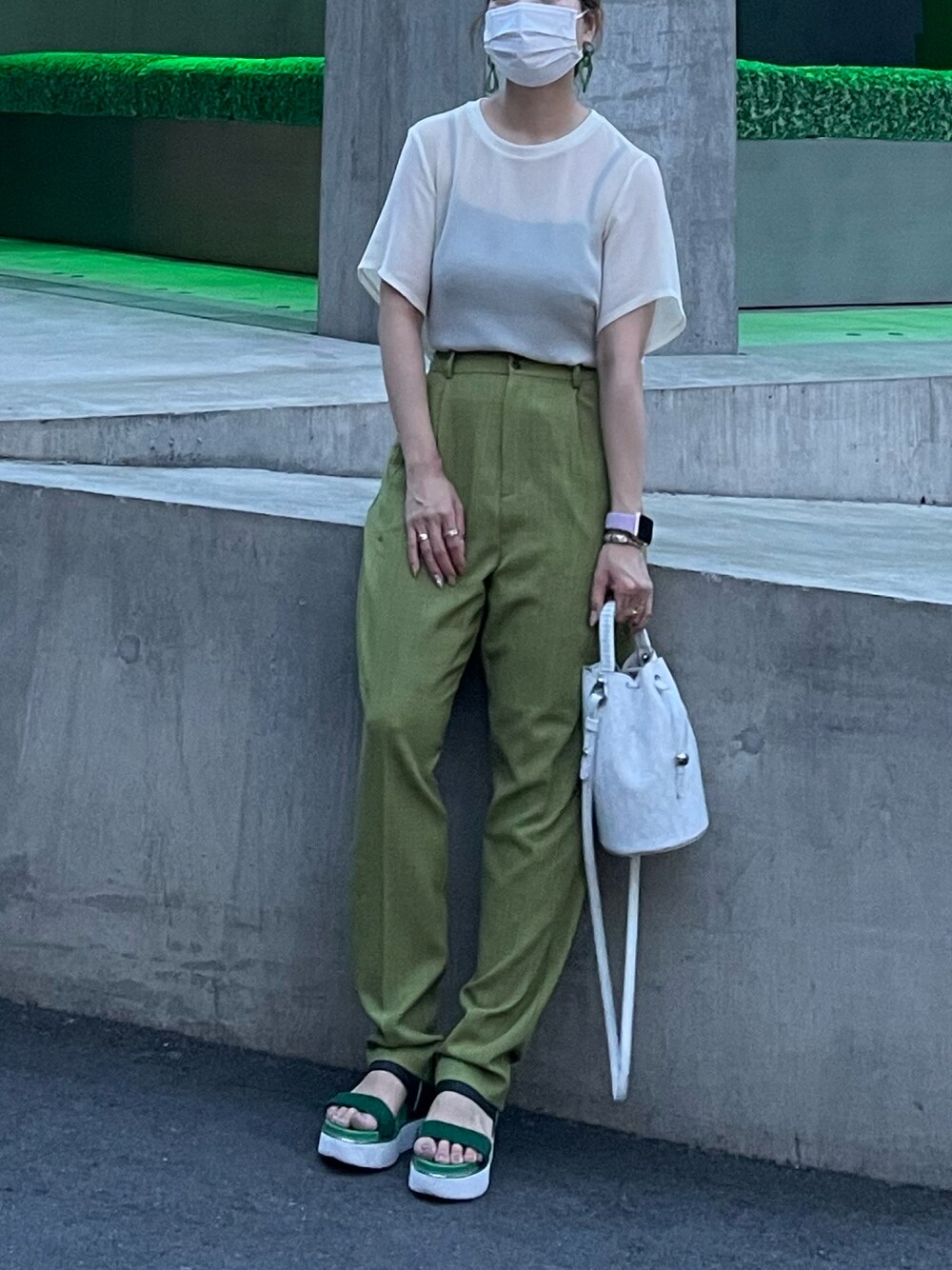 グリーン系のサンダル、ホワイト系のショルダーバッグ、ホワイト系のトップスを着用したレディースの夏コーディネートの1枚目の写真