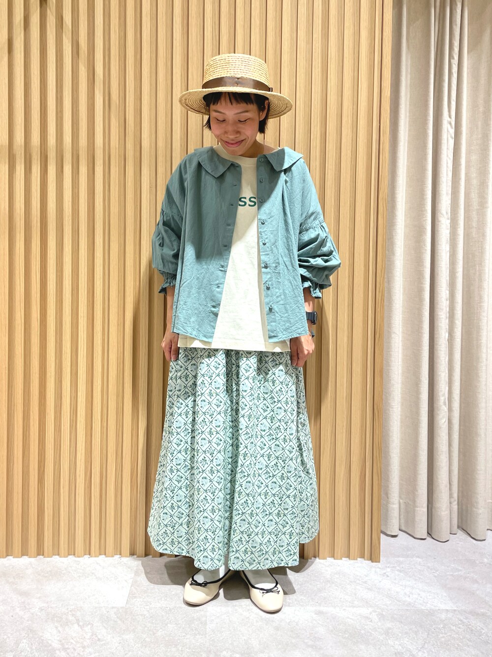 グリーン系のシャツ/ブラウス、グリーン系のスカート、ベージュ系のドレスシューズを着用したレディースの春コーディネートの1枚目の写真