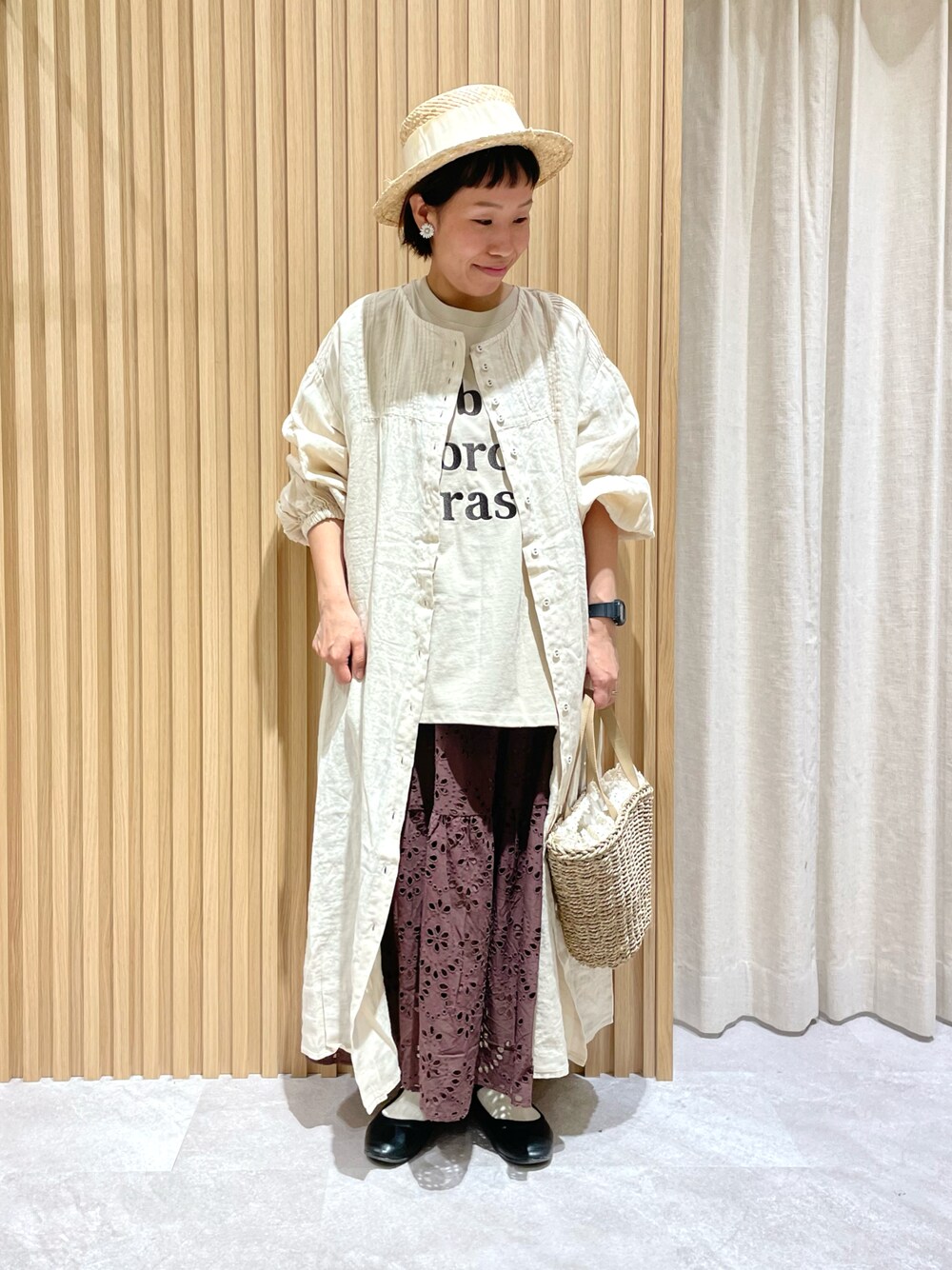 ベージュ系のTシャツ/カットソー、ホワイト系のワンピース、ベージュ系のハンドバッグを着用したレディースの春コーディネートの1枚目の写真