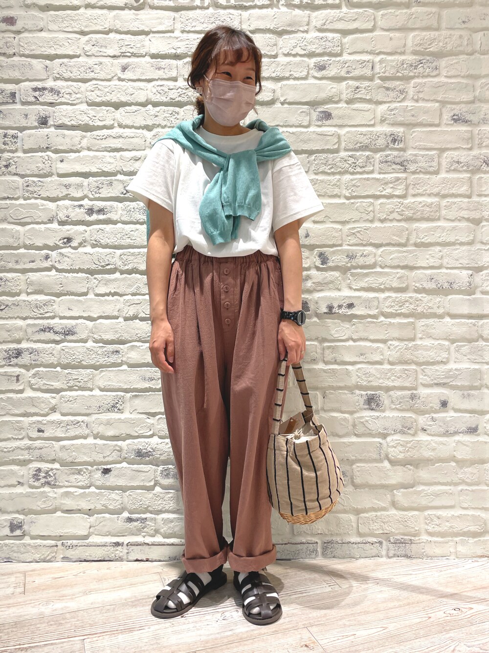 ベージュ系のかごバッグ、ブラウン系のサンダル、ブラウン系のその他パンツを着用したレディースの春コーディネートの1枚目の写真