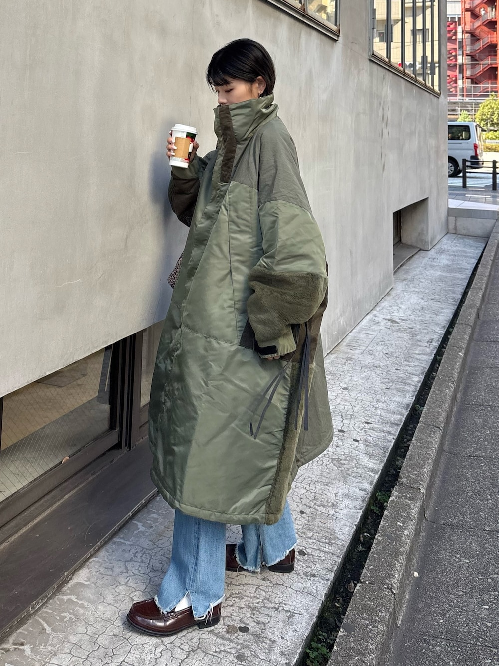 グリーン系のモッズコート、ブルー系のデニムパンツ、ベージュ系のトートバッグを着用したレディースの秋コーディネートの1枚目の写真