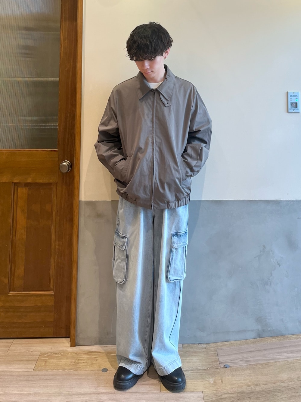 グリーン系のブルゾン、ホワイト系のTシャツ/カットソー、ブルー系のカーゴパンツを着用したメンズの春コーディネートの1枚目の写真