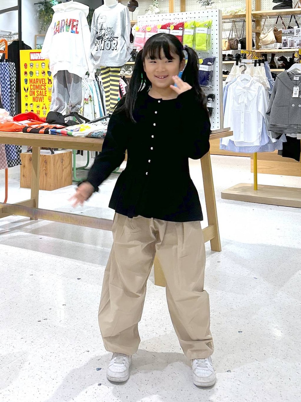 ベージュ系のその他パンツ、ブラック系のカーディガン/ボレロを着用したキッズの春コーディネートの1枚目の写真