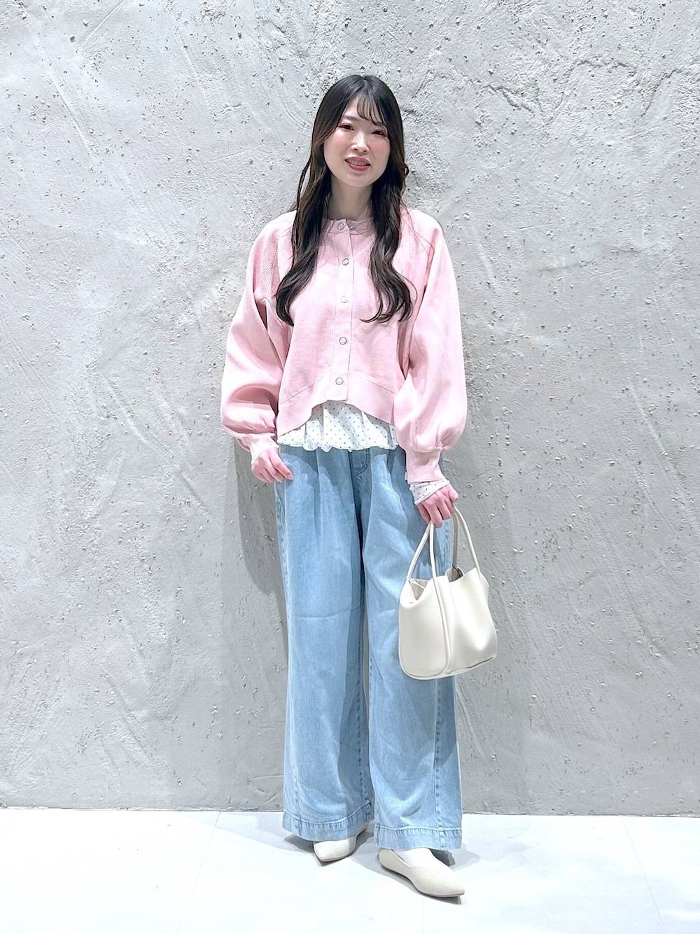 ホワイト系のショルダーバッグ、ブルー系のデニムパンツ、ホワイト系のパンプスを着用したレディースの春コーディネートの1枚目の写真