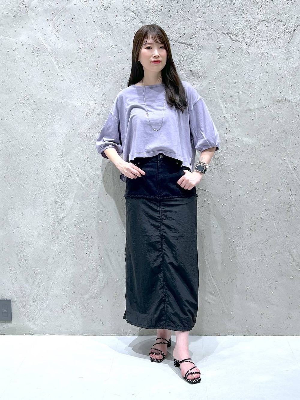 ブラック系のデニムスカート、ブラック系のサンダル、パープル系のTシャツ/カットソーを着用したレディースの夏コーディネートの1枚目の写真