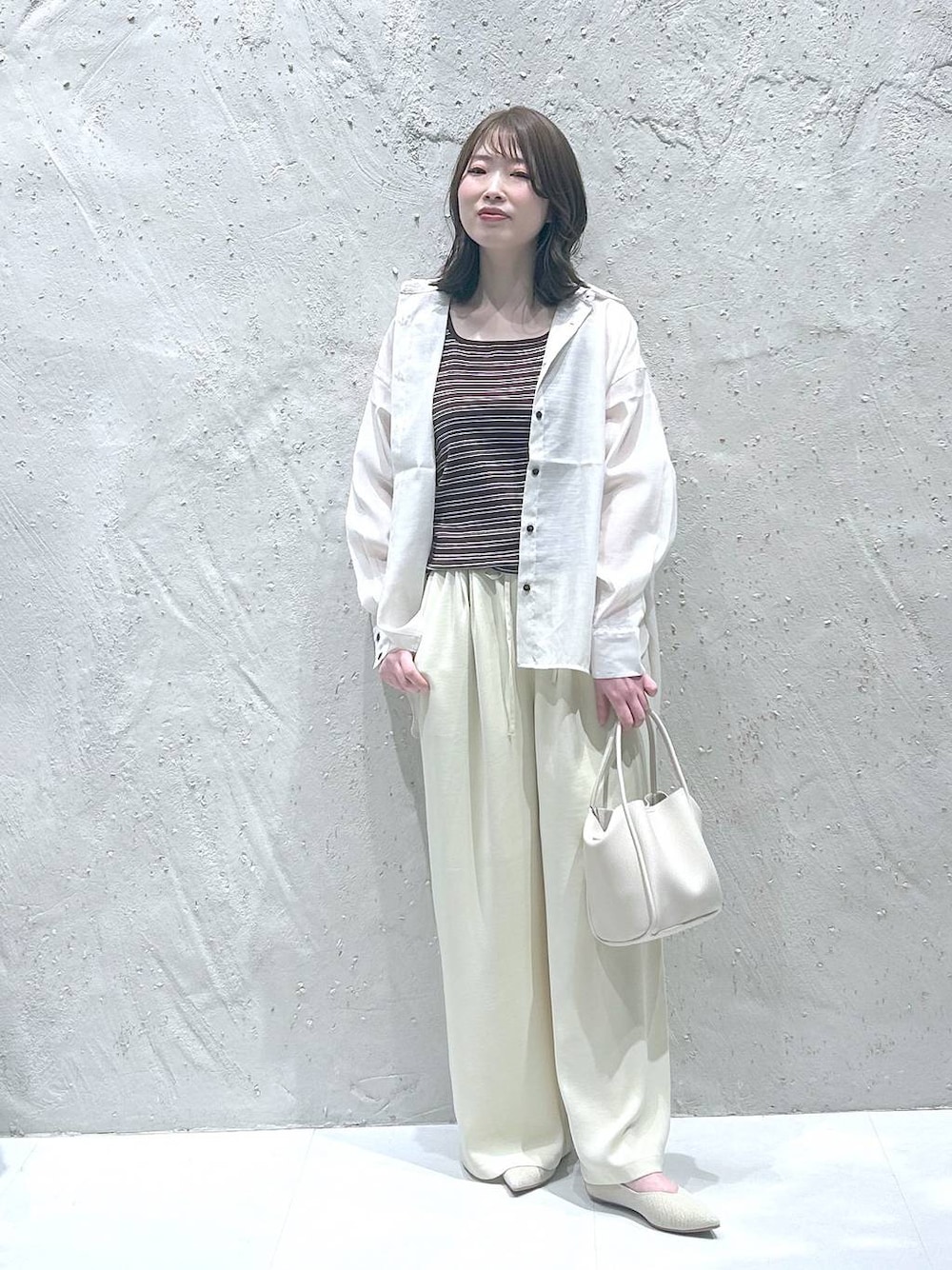 ホワイト系のショルダーバッグ、ホワイト系のシャツ/ブラウス、ホワイト系のパンプスを着用したレディースの春コーディネートの1枚目の写真
